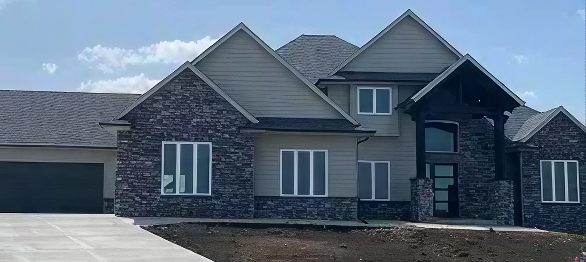 Modern two-story house with stone facade.