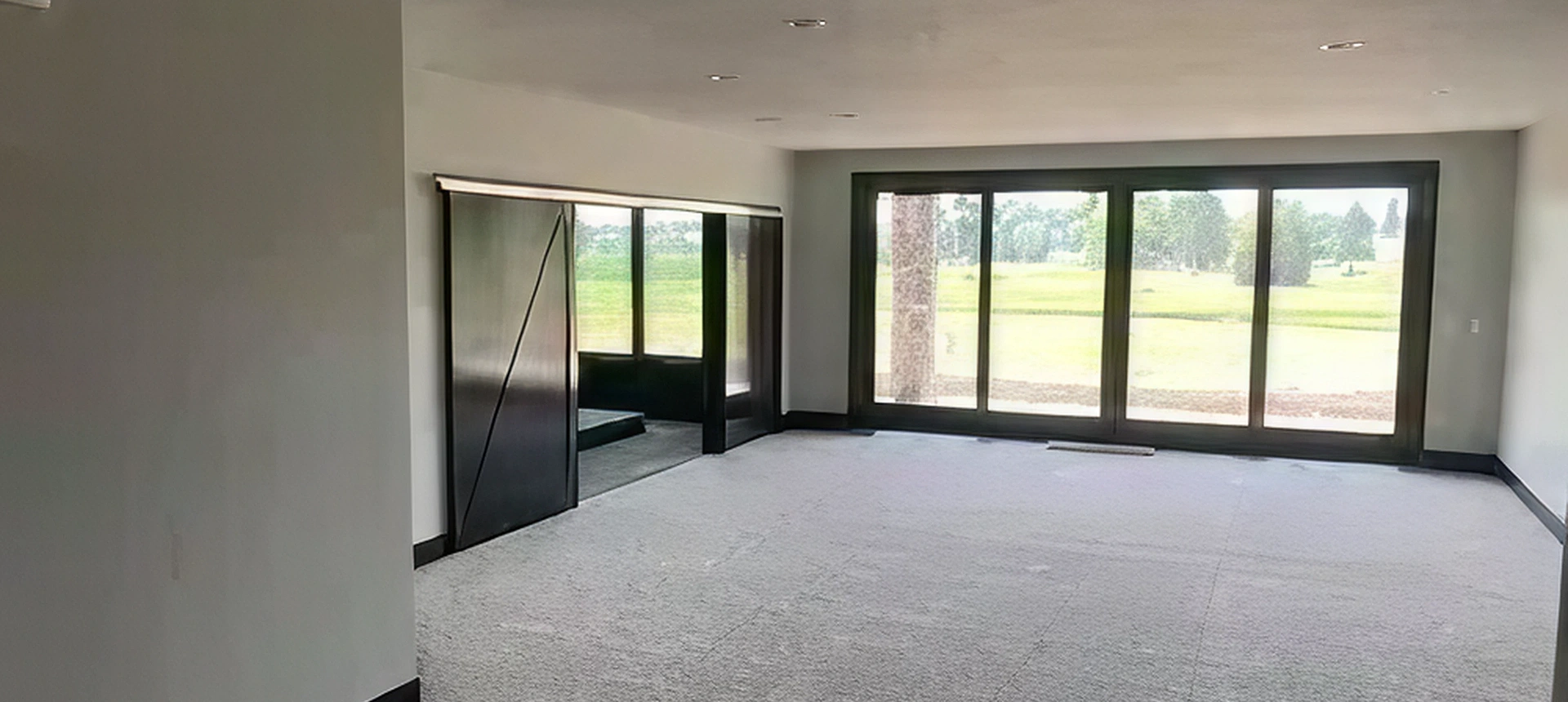 Spacious room with large windows and mirror.